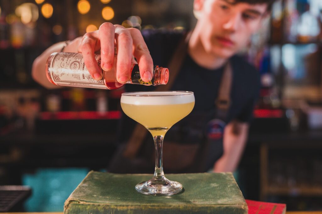 man adding tobasco onto cocktail foam.