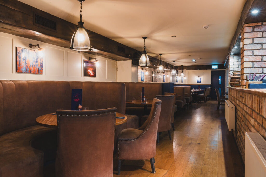 Modern style restaurant dimly lit with brown furniture.