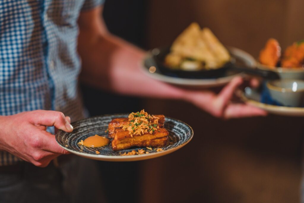 man carrying food dish, starters at The Firehouse